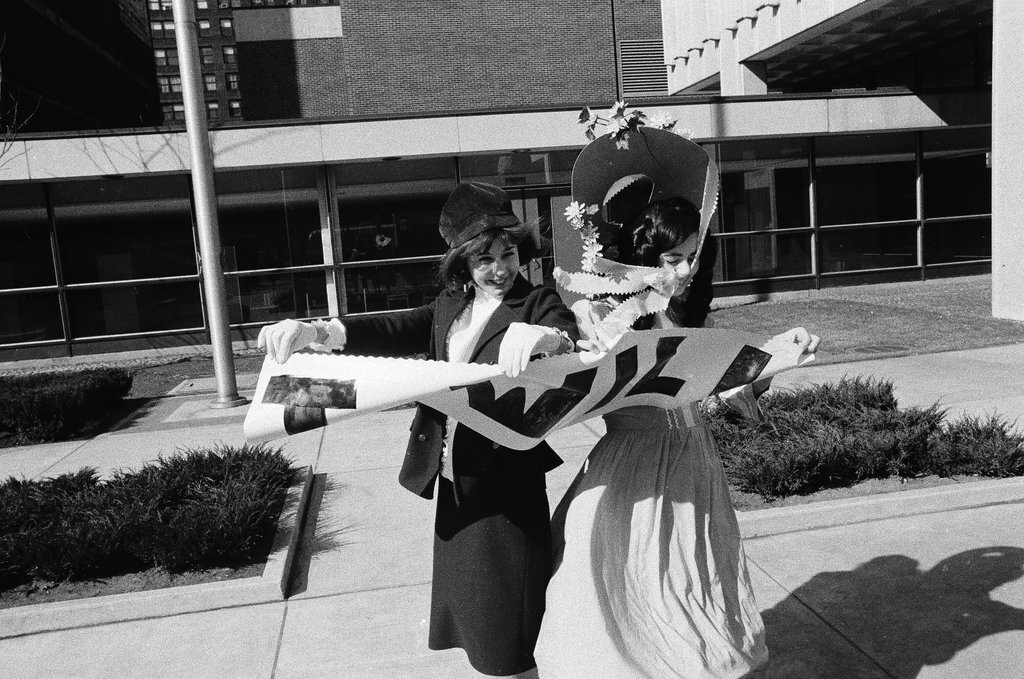 Two students dressed in historical and contemporary costumes holding a banner - Chicago Sun-Times