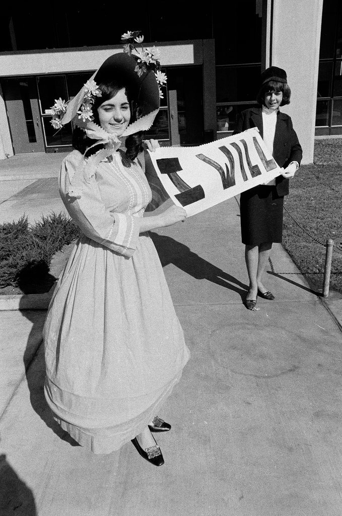 Two students dressed in historical and contemporary costumes holding a banner - Chicago Sun-Times
