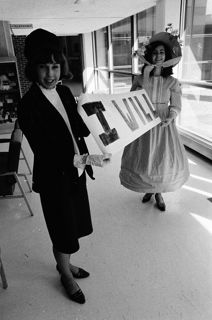 Two students dressed in historical and contemporary costumes holding a banner - Chicago Sun-Times