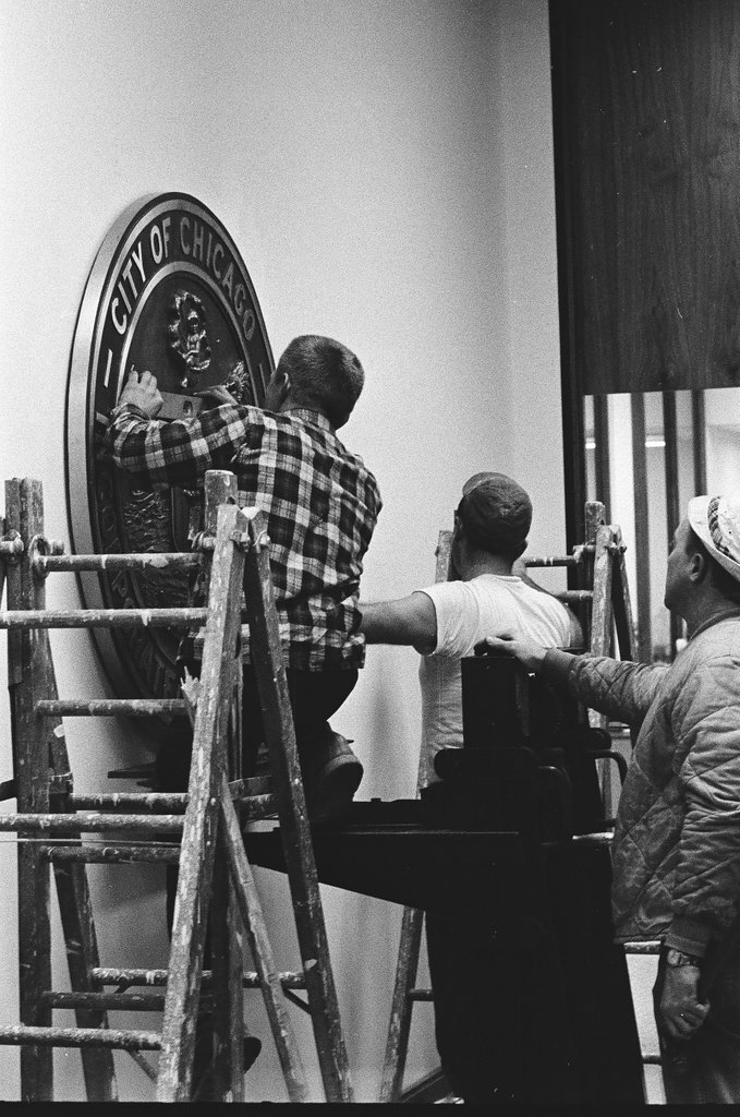 Workmen hang city seal in Mayor's Office - Chicago Sun-Times