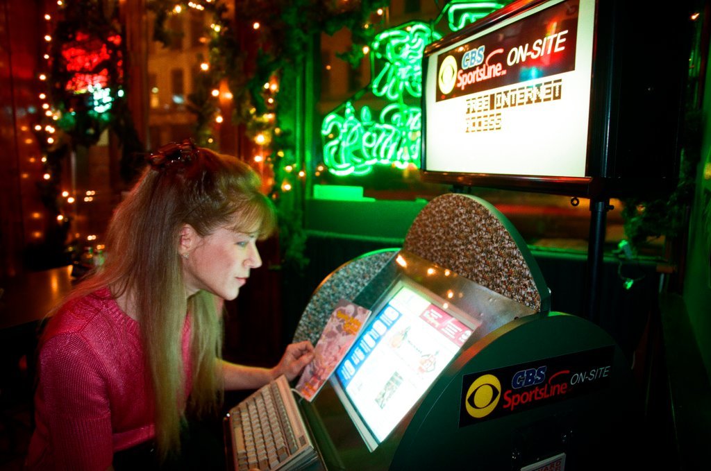 A woman accesses a computer with free internet inside Mother Hubbard's Pub - Chicago Sun-Times