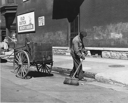 Street cleaner with broom and cart, Old Dutch Root Beer sign at top left - Mead, Mildred