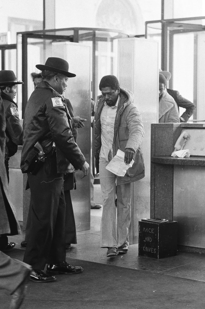 Security officers pat down individuals arriving for John Wayne Gacy's hearing - Richard Derk for Chicago Sun-Times