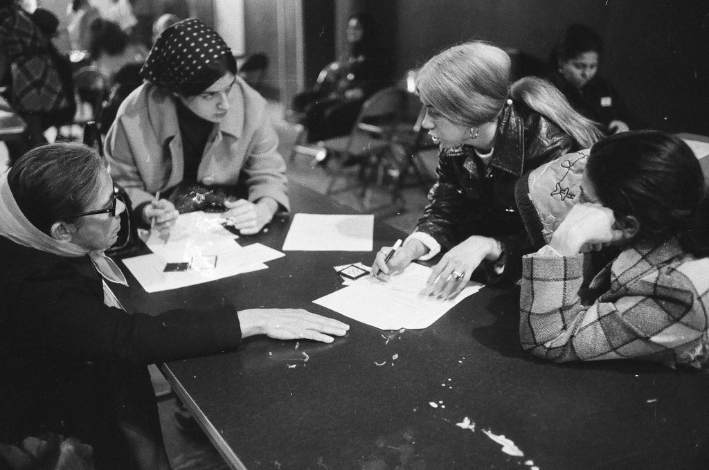 Welfare recipients sign forms at the district public aid office for winter clothing money - Chicago Sun-Times