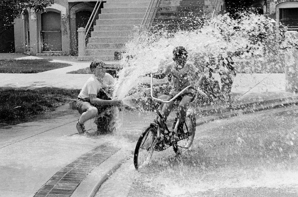 Children play under the spray of an open fire hydrant - Chicago Sun-Times