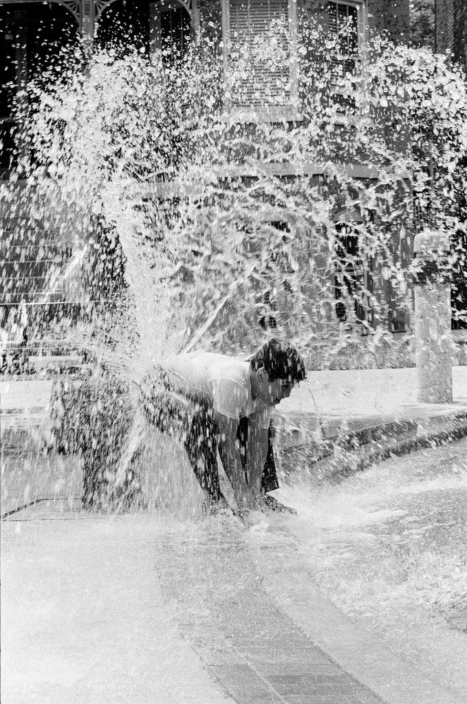 Children play under the spray of an open fire hydrant - Chicago Sun-Times