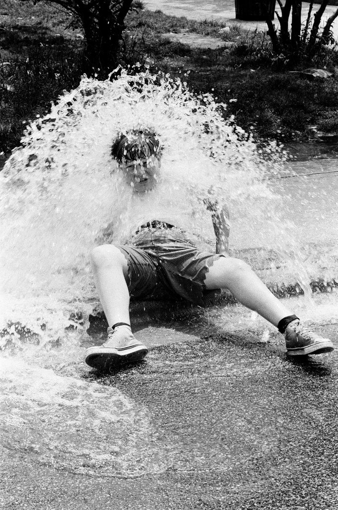 Children play under the spray of an open fire hydrant - Chicago Sun-Times