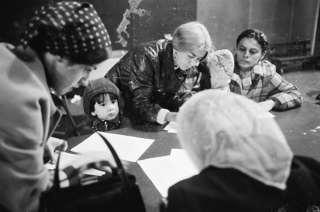 Welfare recipients sign forms at the district public aid office for winter clothing money - Chicago Sun-Times