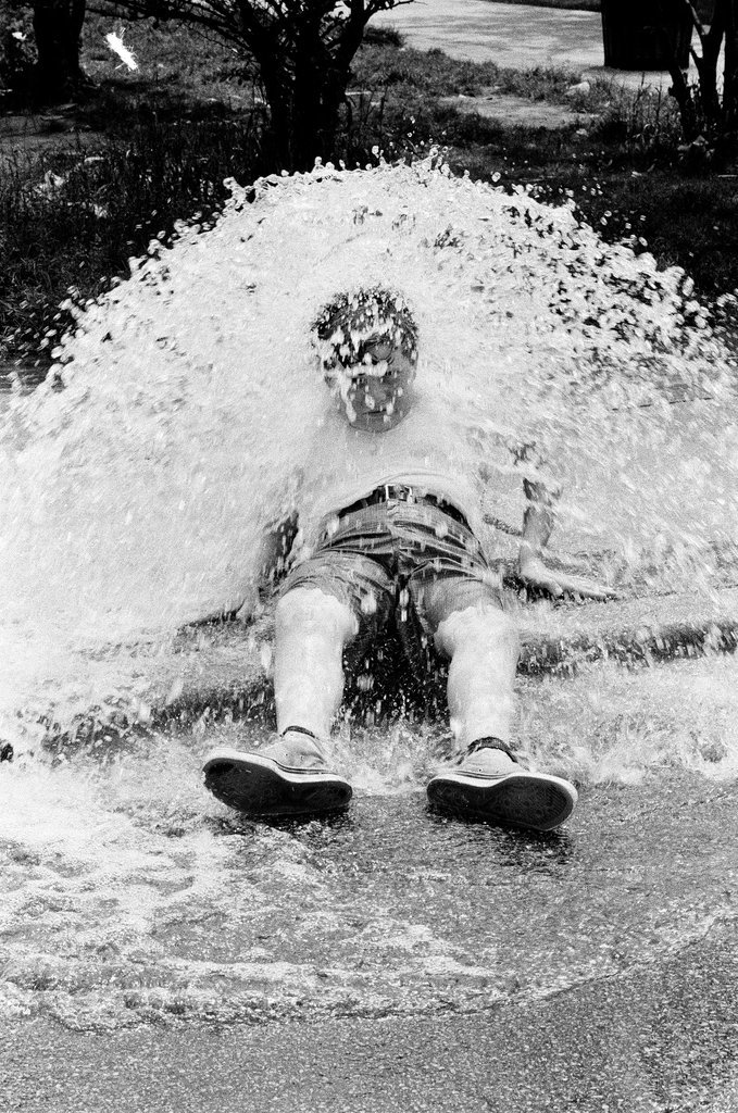 Children play under the spray of an open fire hydrant - Chicago Sun-Times