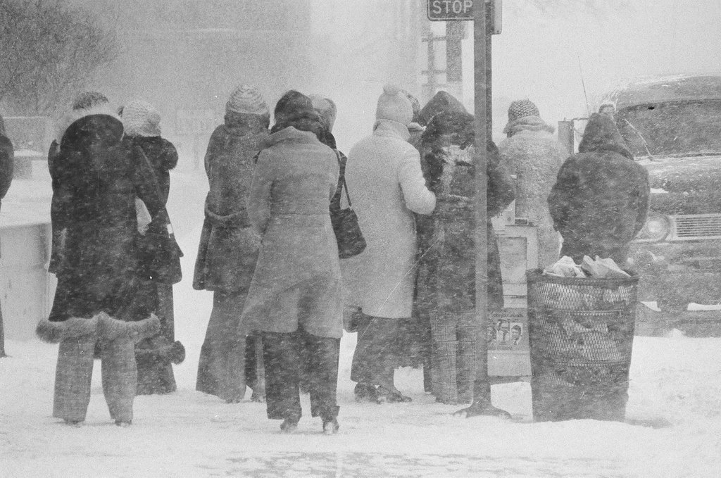 Bus riders huddle by the bus stop in the wind and snow - Chicago Sun-Times