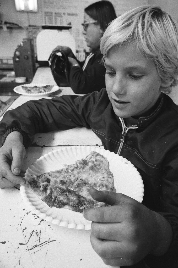 A child eats a slice of pizza from Skippy's Pizza - Chicago Sun-Times