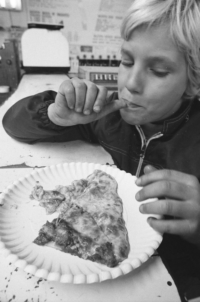 A child eats a slice of pizza from Skippy's Pizza - Chicago Sun-Times
