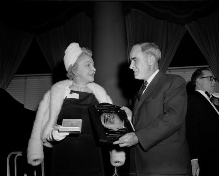 Mrs. William M. Cameron, chairperson of Arden Shore, accepting an award on behalf of Mrs. Harold Wright. Also pictured is John O'Keefe, Pres. of the Madonna Center, who made the presentation. They are attending the Madonna Center Fiesta at the Drake - Chicago Daily News, Inc.