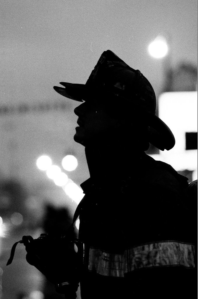 An injured fireman is loaded into an ambulance while remaining firefighters tackle a fire - Chicago Sun-Times