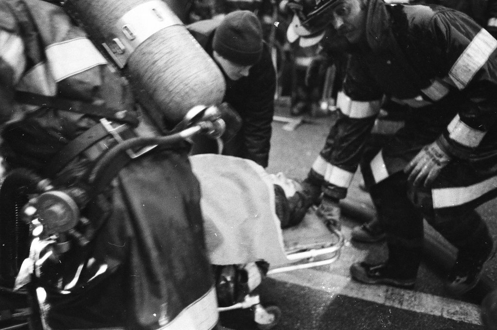 An injured fireman is loaded into an ambulance while remaining firefighters tackle a fire - Chicago Sun-Times
