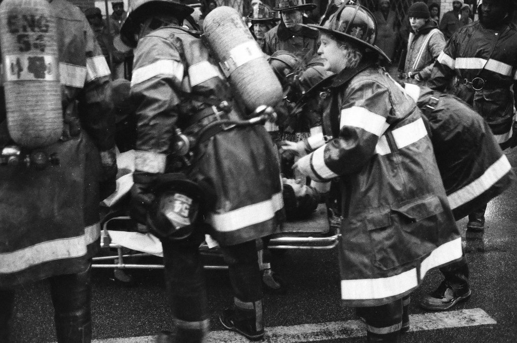 An injured fireman is loaded into an ambulance while remaining firefighters tackle a fire - Chicago Sun-Times