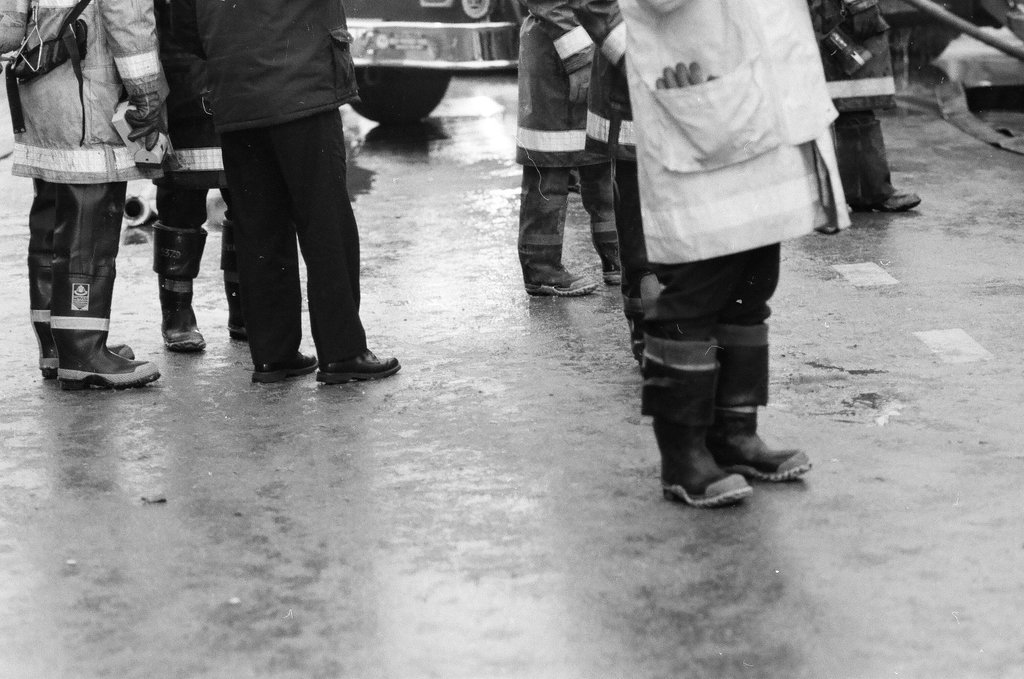 An injured fireman is loaded into an ambulance while remaining firefighters tackle a fire - Chicago Sun-Times