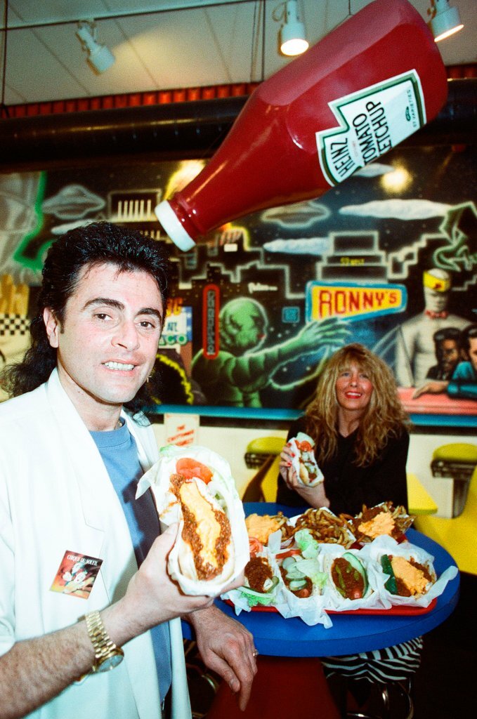 Dimitri Alexander eats a hot dog from his hot dog stand - Chicago Sun-Times